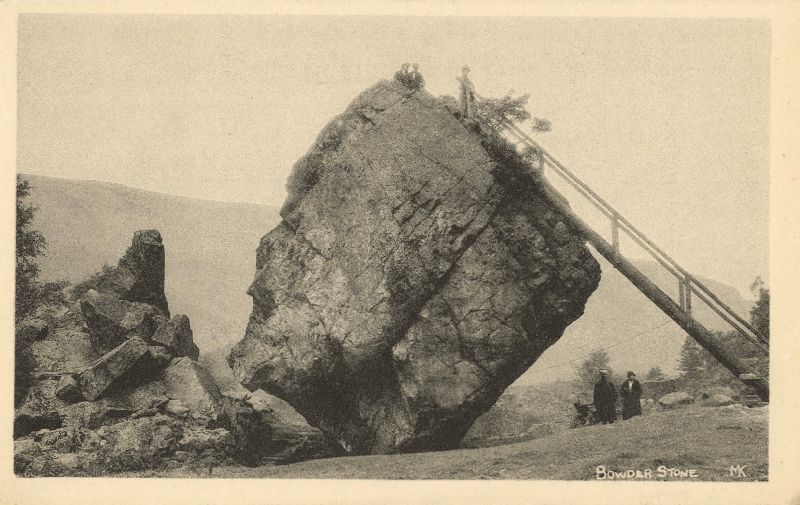 Black & white photo of a big boulder with a wooden ladder leading to the top