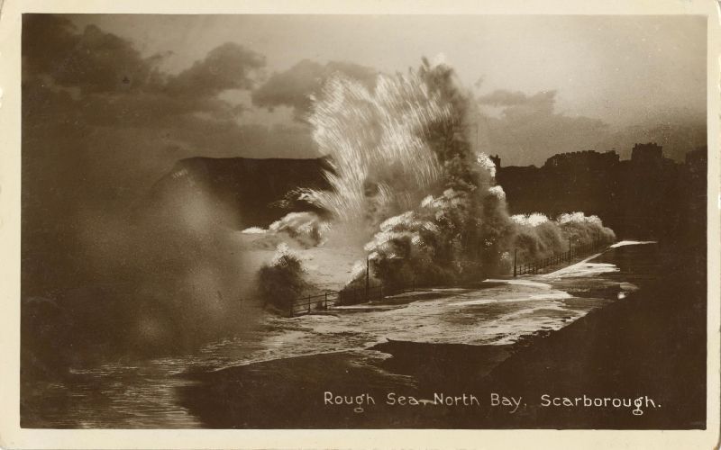 Black & white painting of a large wave crashing into a sea wall along the coast of a sea-side town